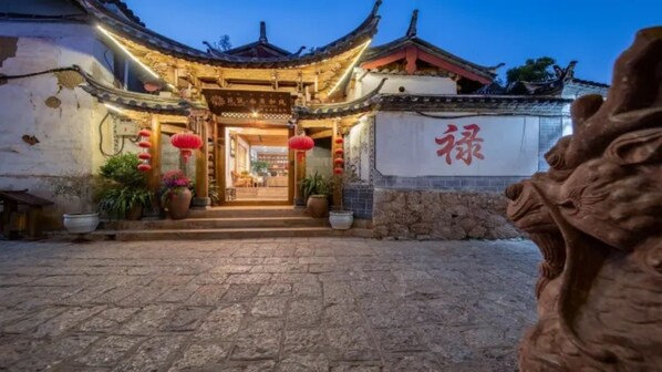 Vista frontal de la propiedad por la tarde o noche