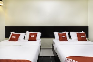 A hotel room with two beds, each with white bedding and red pillows, and a black headboard. - OYO 89960 Manjung Inn Hotel (Sitiawan)