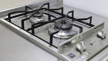 A gas stove with four burners and a control panel.