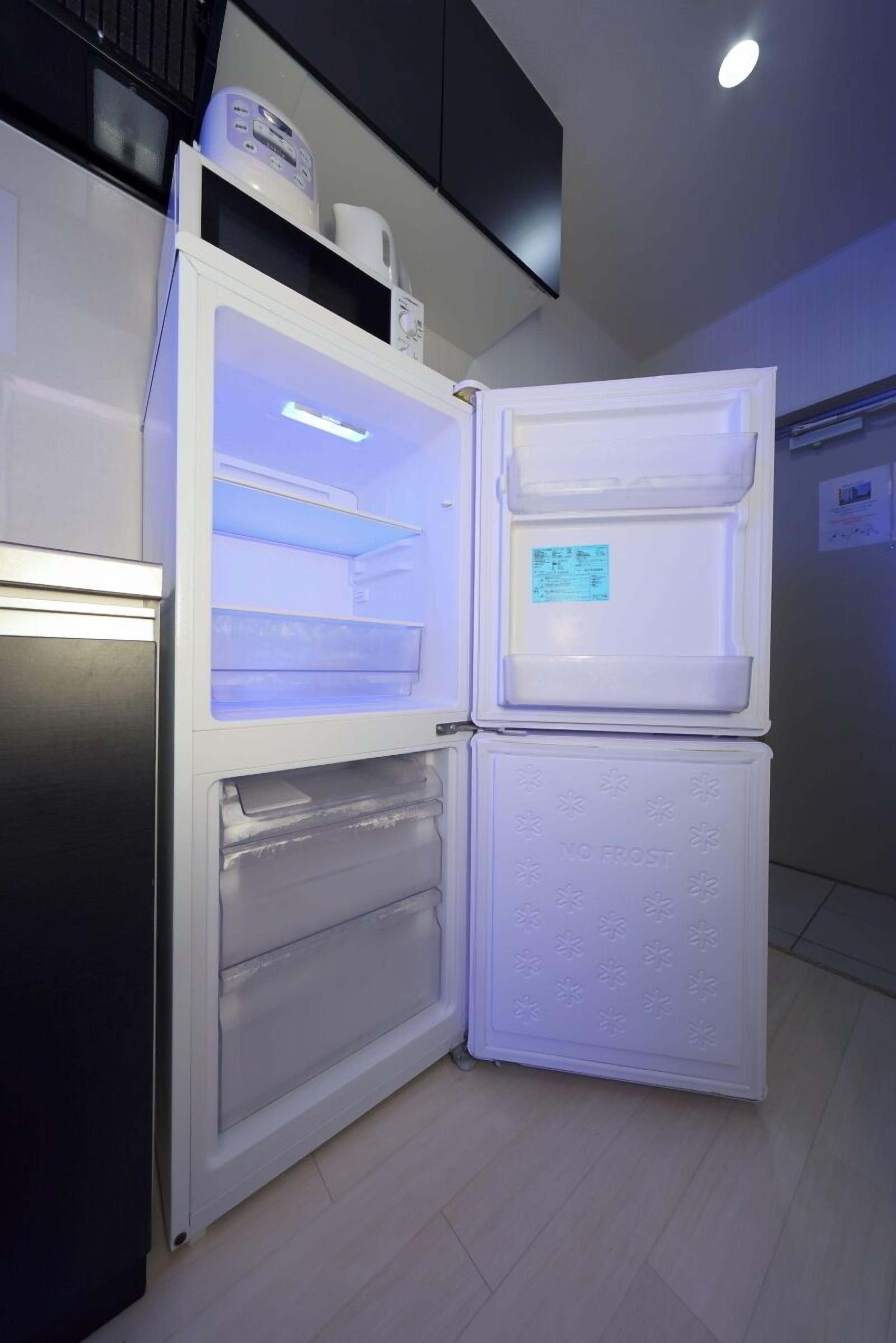 Un réfrigérateur compact doté d’un compartiment congélateur situé en haut et d’un compartiment principal en dessous, les deux étant équipés de portes en verre transparent.