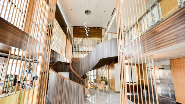 A modern hotel lobby with a central spiral staircase, polished marble floors, and contemporary furnishings. -  Lovina at One Residence (Batam)