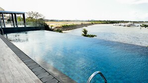 A clear view of a swimming pool with a view of the river and boats in the background. -  Lovina at One Residence (Batam)