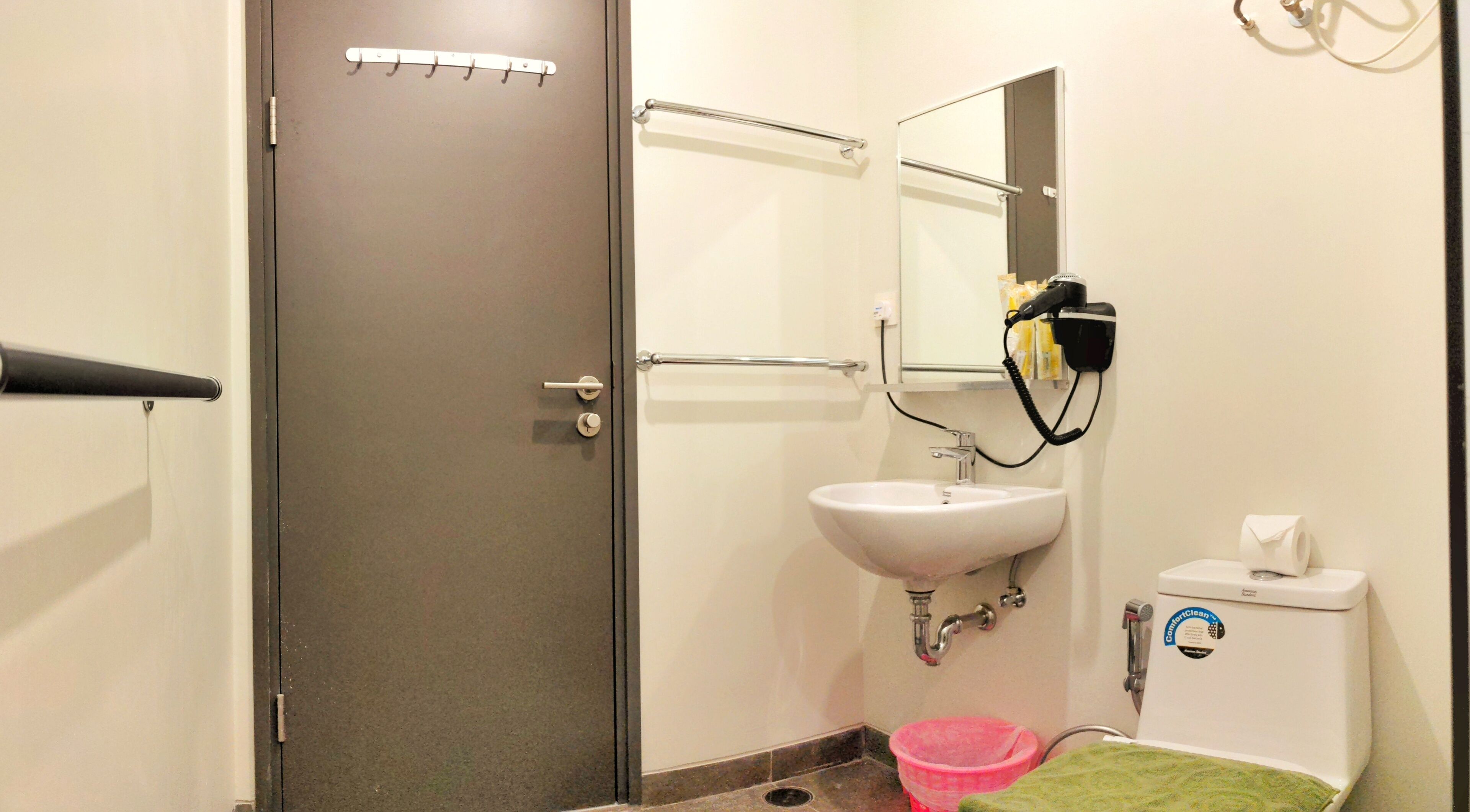 A bathroom with a sink, mirror, towel rack, and a toilet.