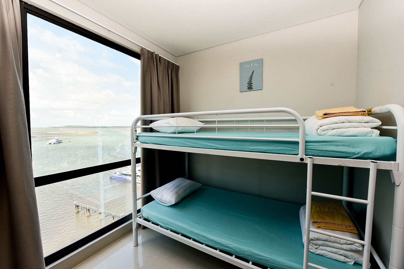 Camera con letto a castello e vista sul mare e su una barca.