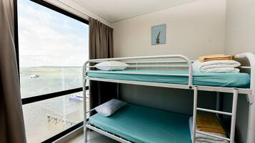 Camera con letto a castello e vista sul mare e su una barca.