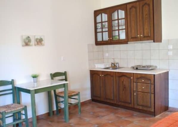 A kitchen with wooden cabinets, a tiled backsplash, and a dining table with chairs.