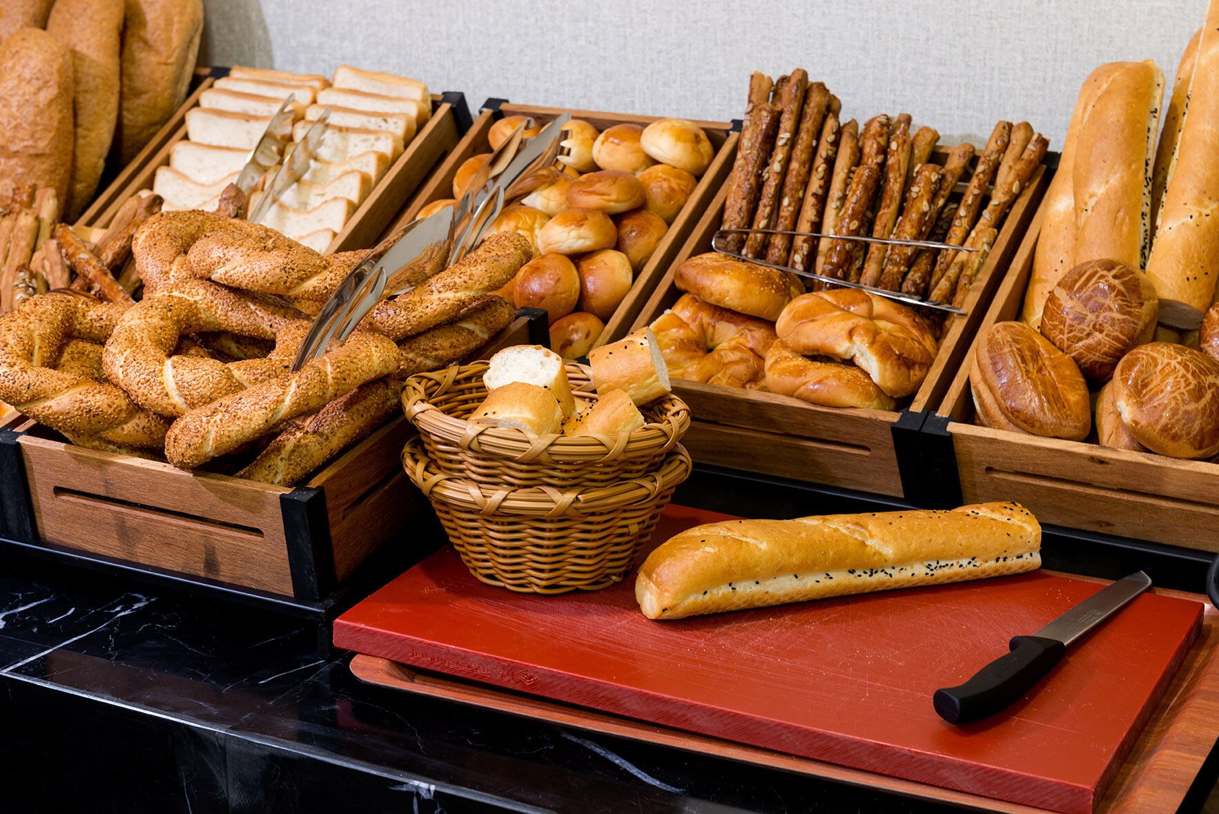 Verschiedene Brotsorten und Gebäcke werden in Holzkisten und Körben präsentiert.