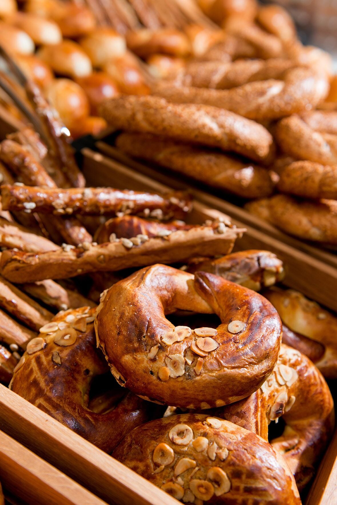 A variety of baked goods, including pretzels and a large, round pastry topped with sliced almonds.