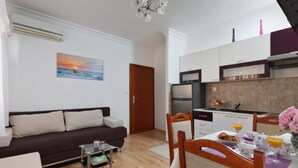 A compact living space with a kitchenette, a dining area, and a sofa. - Tihi Val Apartments (Split)