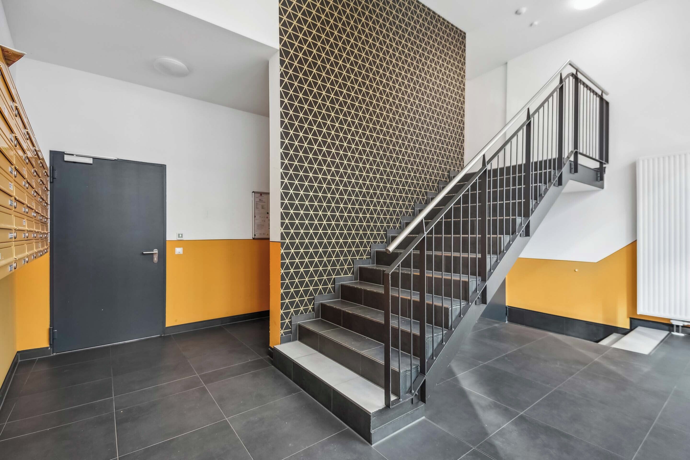 Ein modernes Interieur mit Treppe, einer Tür und einer Wand mit Muster.