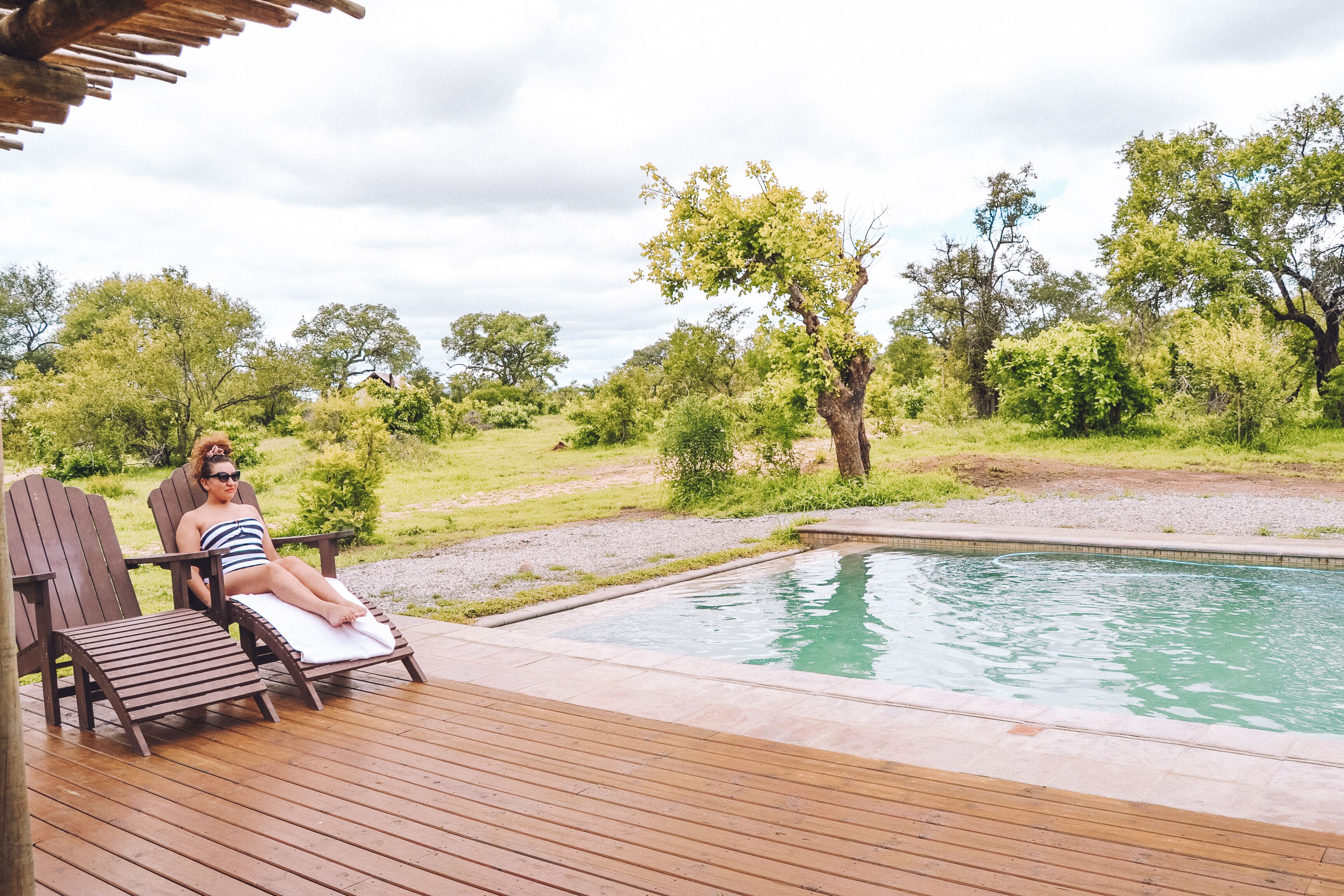 A pool area with wooden deck and lounge chairs.