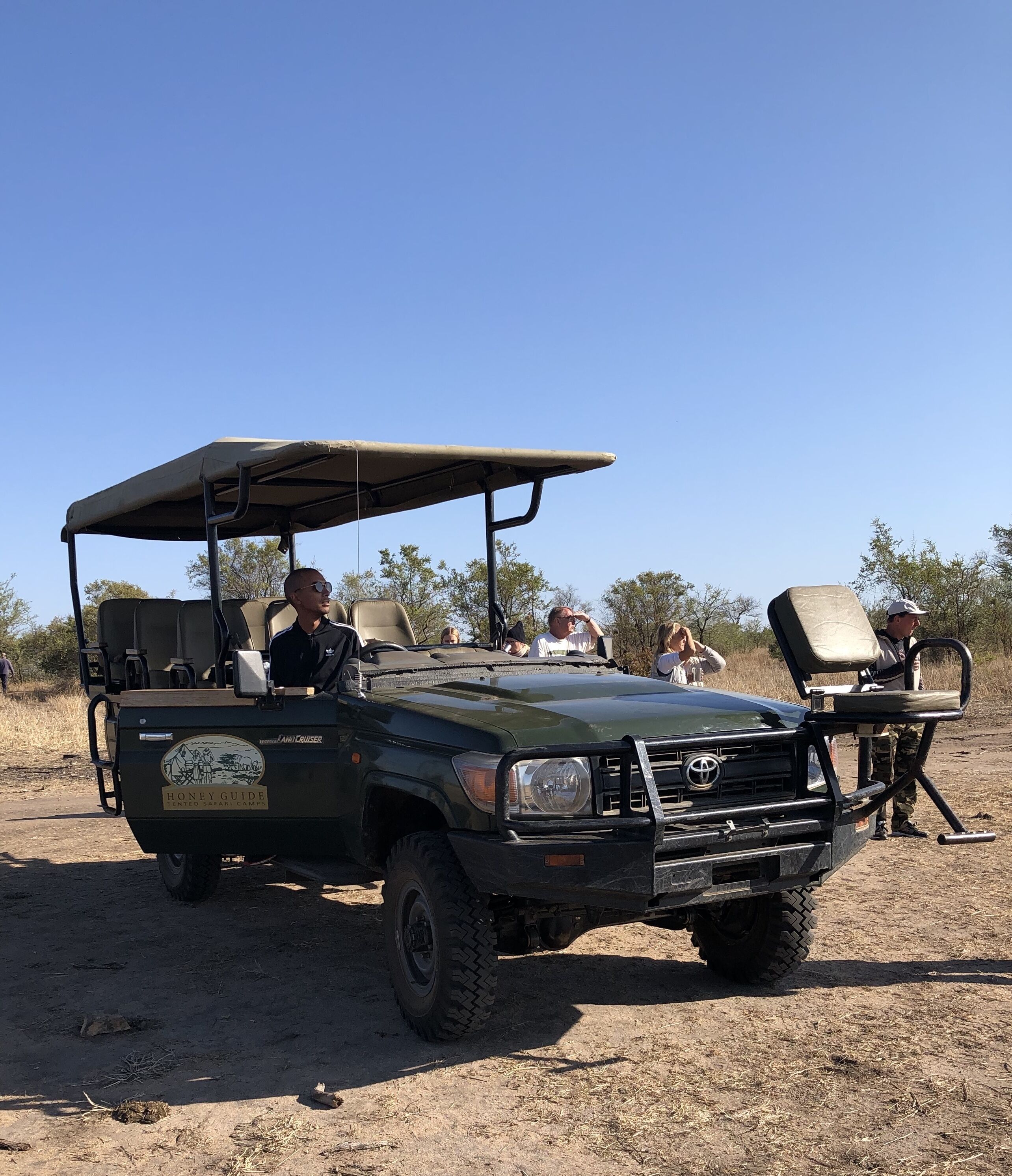 A safari vehicle with a roof, seating, and a luggage rack.