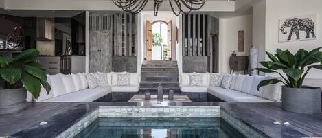 Una piscina al aire libre, sillones reclinables de piscina