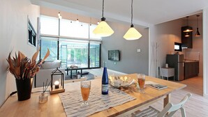 Eine moderne Küche mit Essbereich, großen Fenstern und Blick ins Freie.