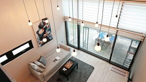 Ein modernes Wohnzimmer mit einer Couch, einem Couchtisch und Kunstwerken an der Wand.