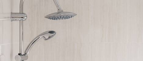 A modern shower with a handheld showerhead and a fixed overhead showerhead.