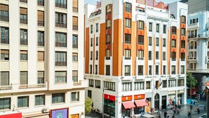 A multi-story hotel with balconies, a central courtyard, and various shops on the ground floor. - Smartr Madrid Gran Vía 47 (Madrid)