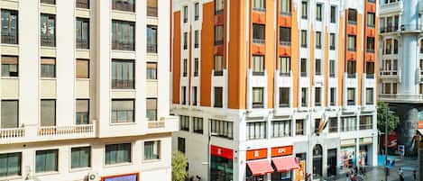 A multi-story hotel with balconies, a central courtyard, and various shops on the ground floor.