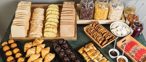 Eine Auswahl an Backwaren und Brot, darunter Croissants, Muffins und Sandwiches.