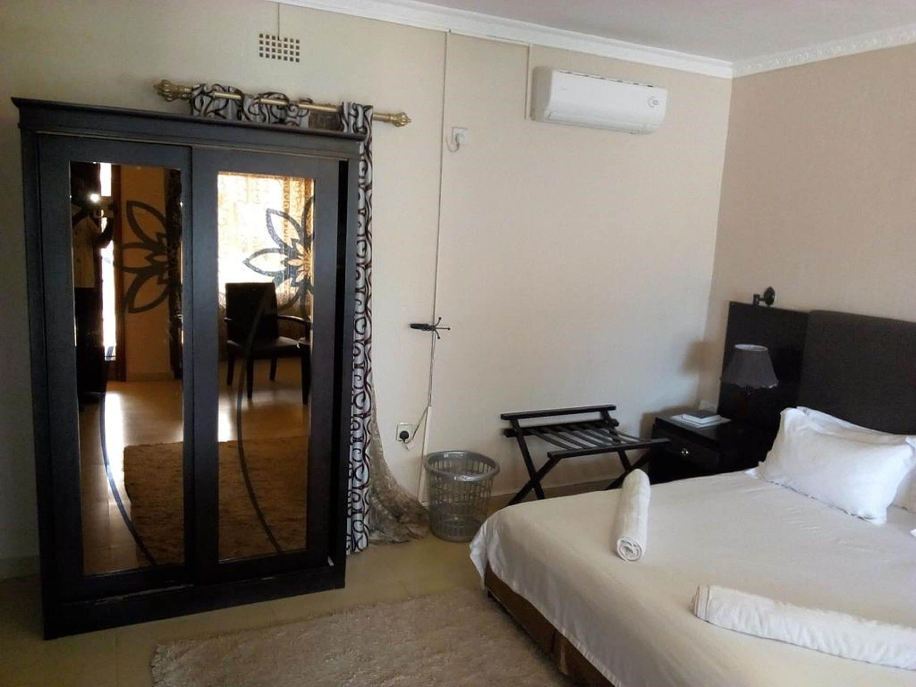 Un dormitorio con cama, armario, escritorio y silla.