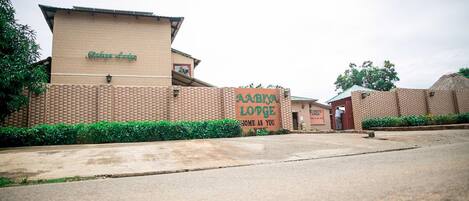 Un edificio de ladrillo con un letrero que dice "AABYA LODGE HOME AS YOU WANT".