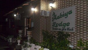 Un edificio con un letrero que dice "Abyia Lodge" y el eslogan "Hogar como deseas".