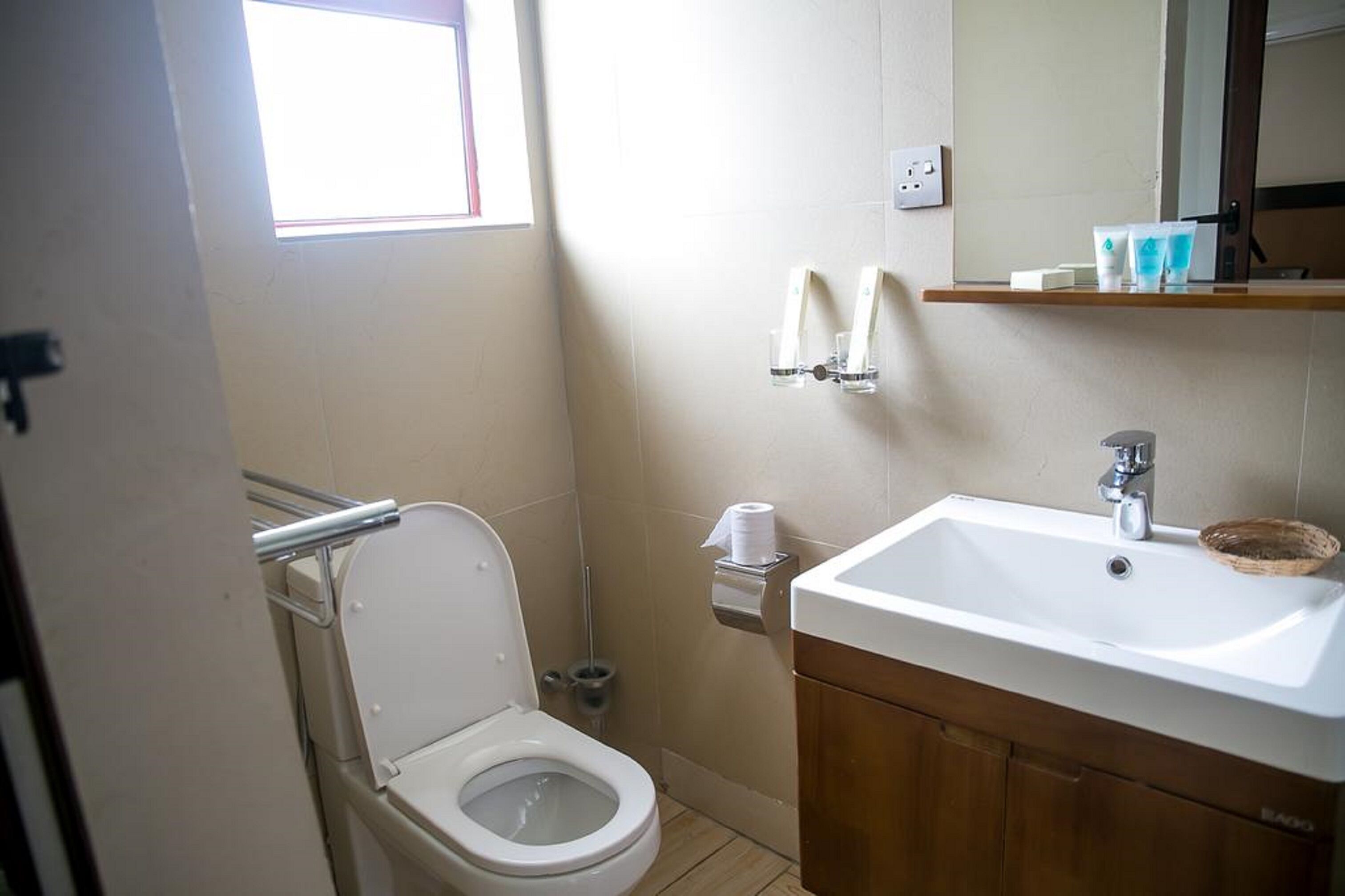 Un baño con inodoro, lavabo y perchero para toallas.