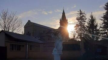 Una piscina con una statua al centro, circondata da edifici e alberi.
