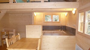 A compact kitchen with a dining table and chairs, a window, and a built-in sink.