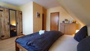 A bedroom with a bed, a wardrobe, and a dresser. - FeWo Düneneck 14- OG (3) (St. Peter-Ording)
