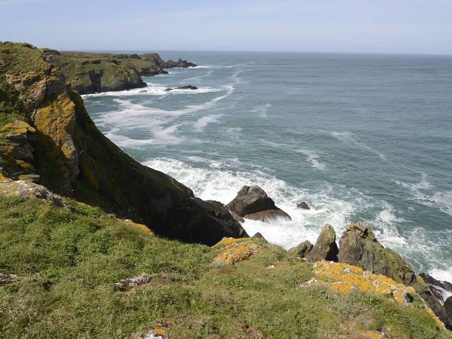 A coastal landscape with rocky cliffs and the ocean.
