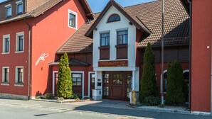 Ein zweistöckiges Gebäude mit einem Schild, auf dem 'FRANKISCHER HOF' steht.