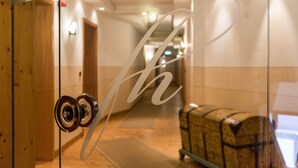Ein Hotel mit einem Glastür, einem Holzrahmen und einem Gepäckwagen im Hintergrund.