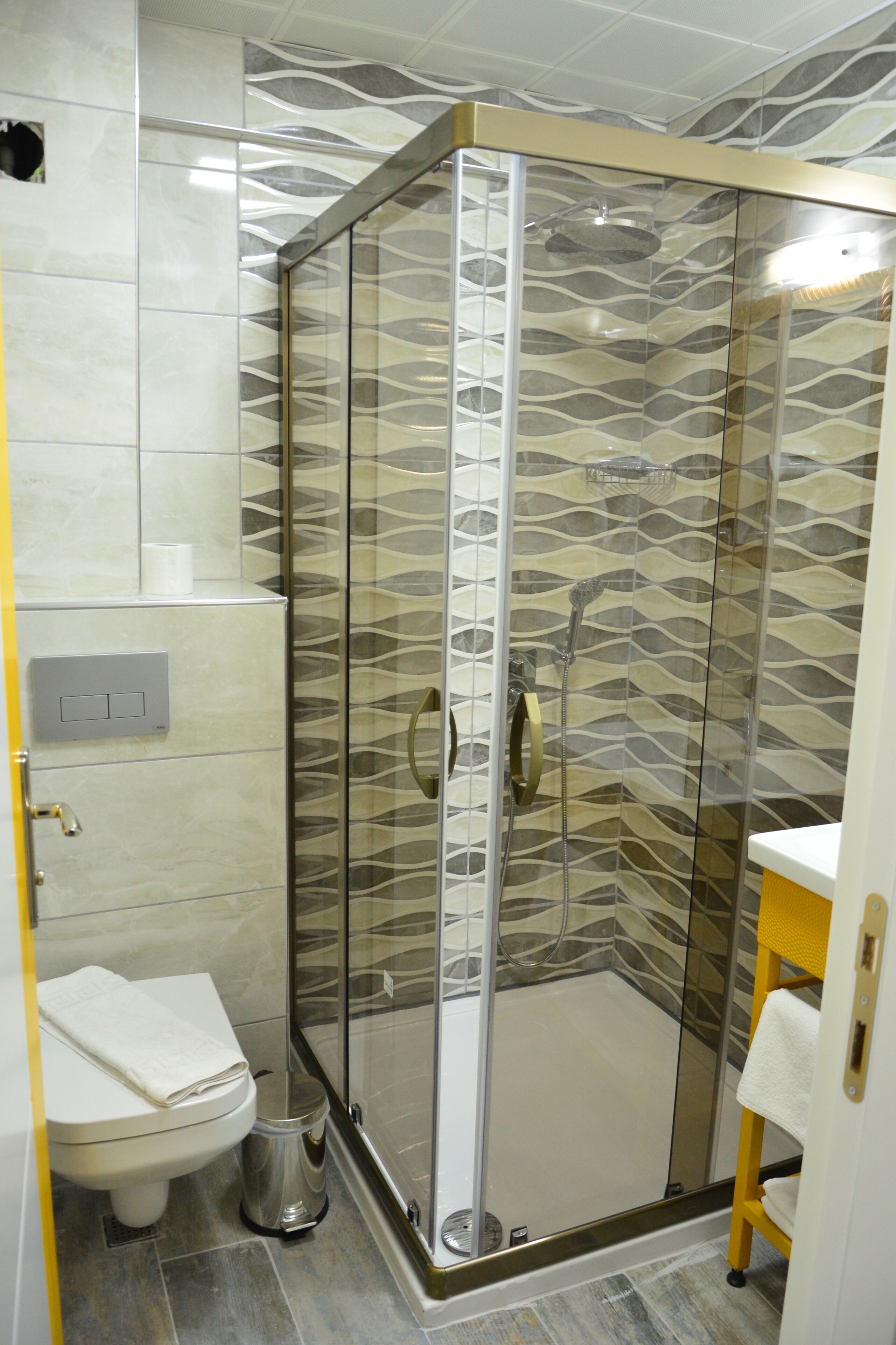 Ein Badezimmer mit einer Duschkabine, einer Toilette und einem Waschbecken.