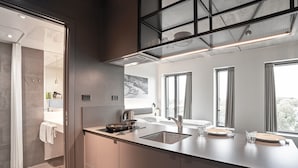 A modern kitchen with a large island, stainless steel appliances, and a view of the city through large windows.