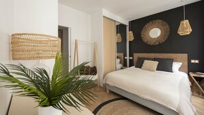 Un dormitorio moderno con una cama grande, un espejo y dos lámparas colgantes.