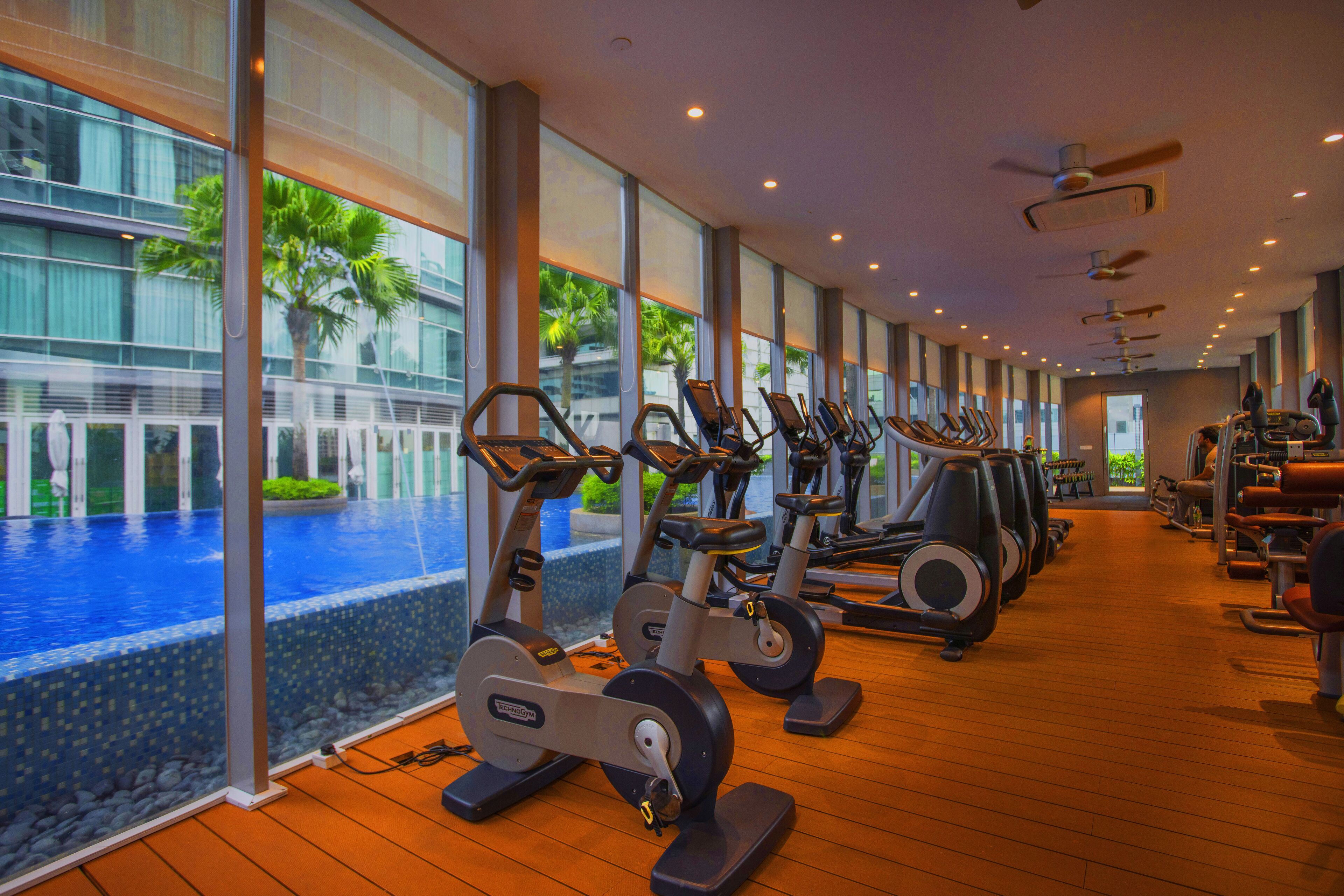 Une salle de sport équipée de vélos d’appartement, de tapis de course et d’autres appareils de musculation.