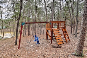 Explore the forest playground with a swing set, ladder, and slide.