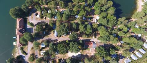 An aerial view of a lakeside property with multiple cabins, a main building, and a dock.