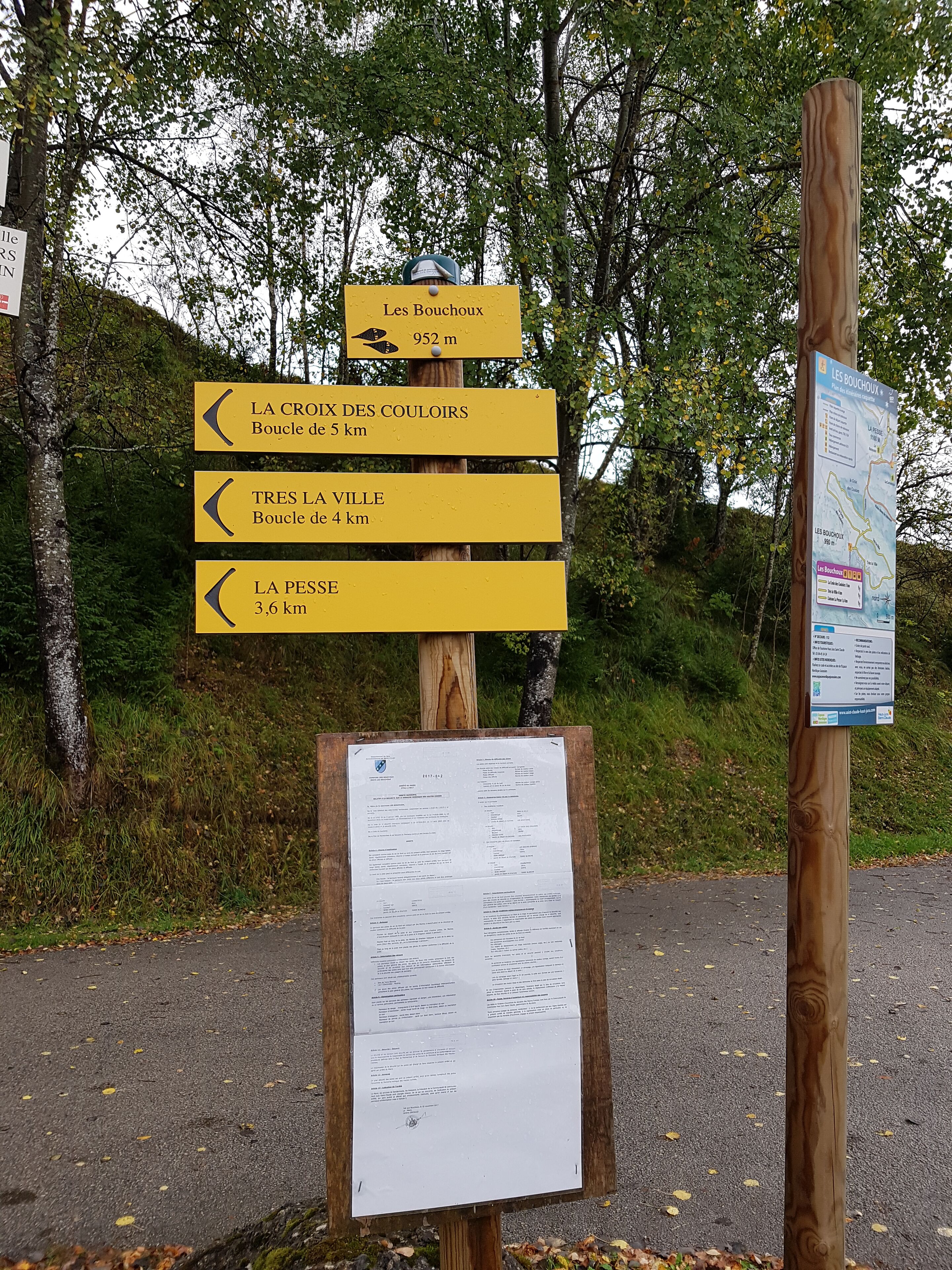 A directional signpost with multiple yellow arrows indicating distances to various destinations.