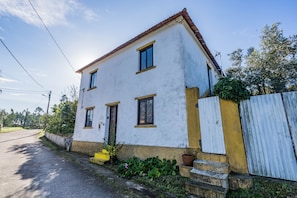 A two-story house with a white exterior and a red-tiled roof. - Beautiful country house in Monte Vale Grande. Very quiet rural area. (Soure)