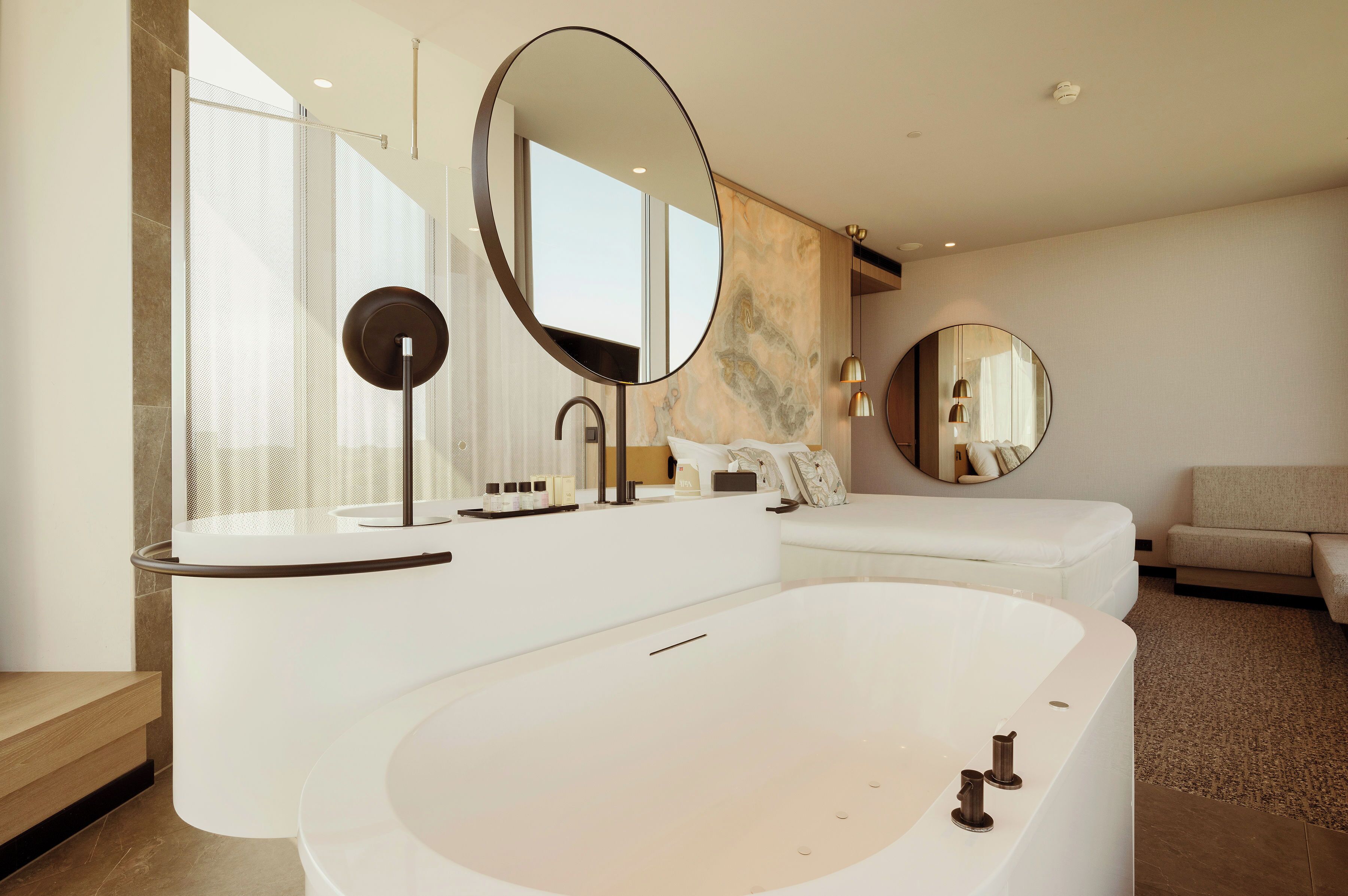 Un baño moderno con una bañera grande, dos lavamanos y un espejo amplio.