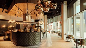 Un intérieur moderne avec un bar central, de grandes fenêtres et des luminaires contemporains.