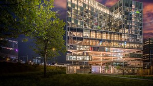 Un hôtel moderne doté d’une façade en verre, de plusieurs étages et d’une enseigne bien visible portant le nom « VANDERVALK ».