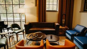 A cozy room with a leather sofa, blue armchairs, and a small coffee table.