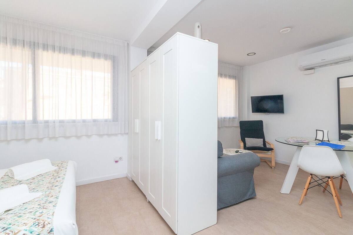 Ein modernes Hotelzimmer mit Bett, Schreibtisch, Stuhl und Fernseher.