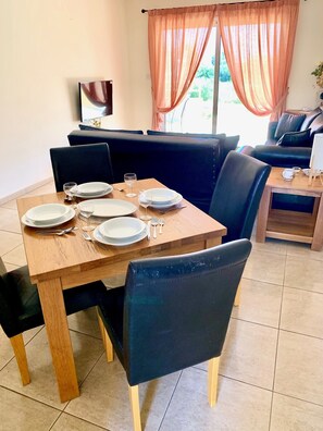 Enjoy meals in this dining area with a table for four, surrounded by comfortable seating and a sofa.