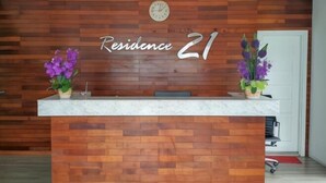 A reception desk with a wooden wall background and the text "Residence 21". - Residence 21 Boutique Inn (Miri)