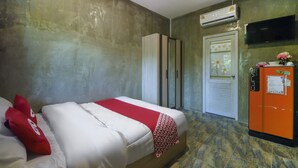 Quarto de hotel com cama, guarda-roupa, ar condicionado, televisão e frigorífico.