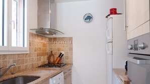 A compact kitchen with a sink, stove, and oven. There is a window with a view of the outside. - 3 bedroom house near Santa Giulia beach Residence heated swimming pool (Porto-Vecchio)